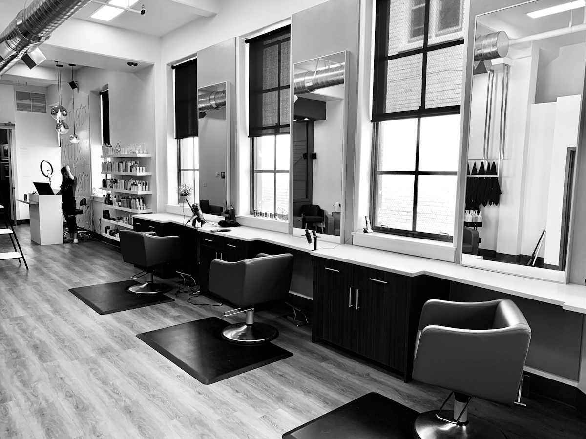 Black-and-white salon with a row of chairs under tall windows